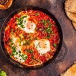 Shakshuka z bakłażanem, cebulą w sosie pomidorowo-śmietankowym, trzema jajkami, pieczywem.